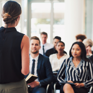 A presenter speaks to a seated group of employees.